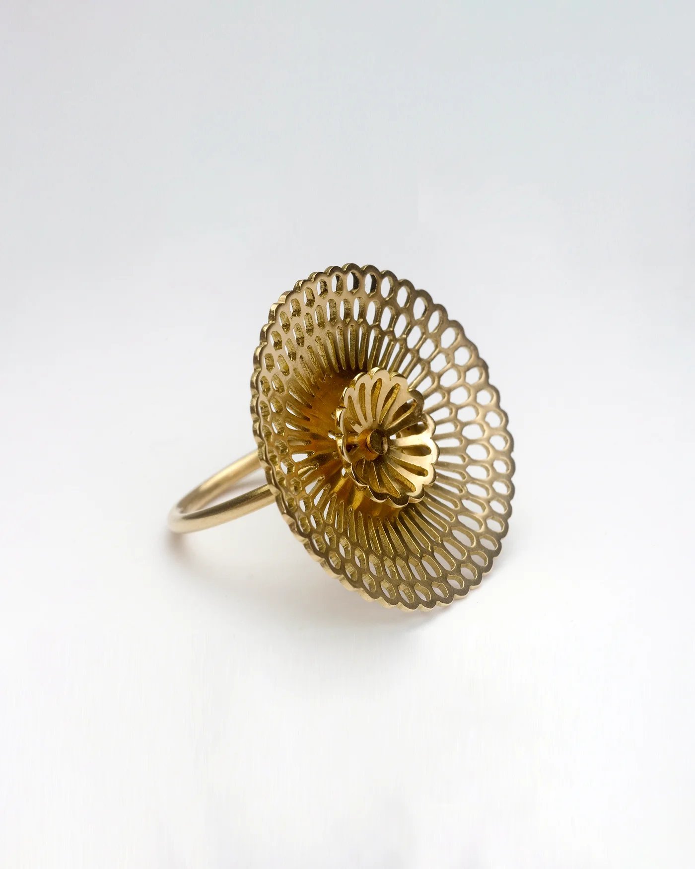 A sculptural gold-coloured ring with a layered, openwork circular flower.