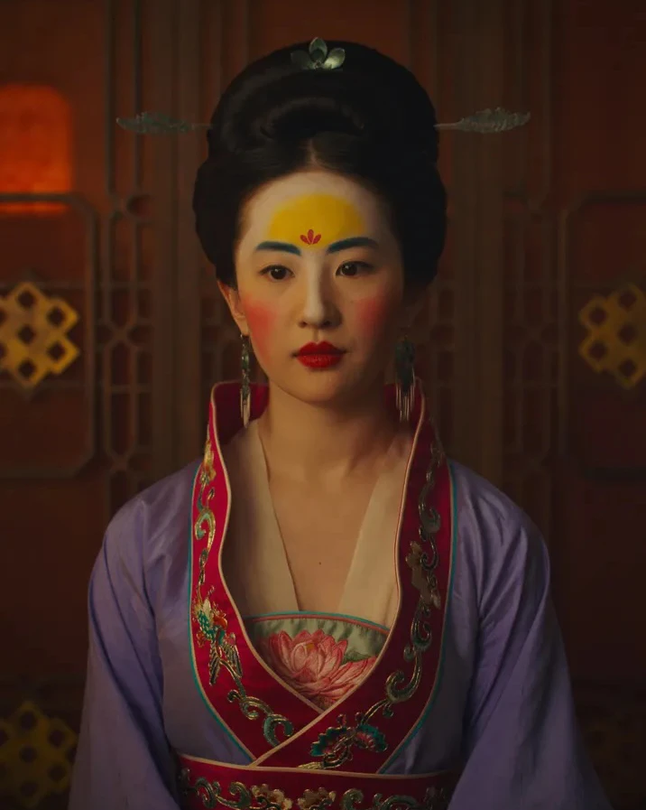 Film costume with long earrings, ornate hair ornaments and a necklace against purple silk.